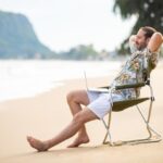 Caucasian-businessman-sitting-outdoor-chair-working-laptop-computer-business-currency-stocks